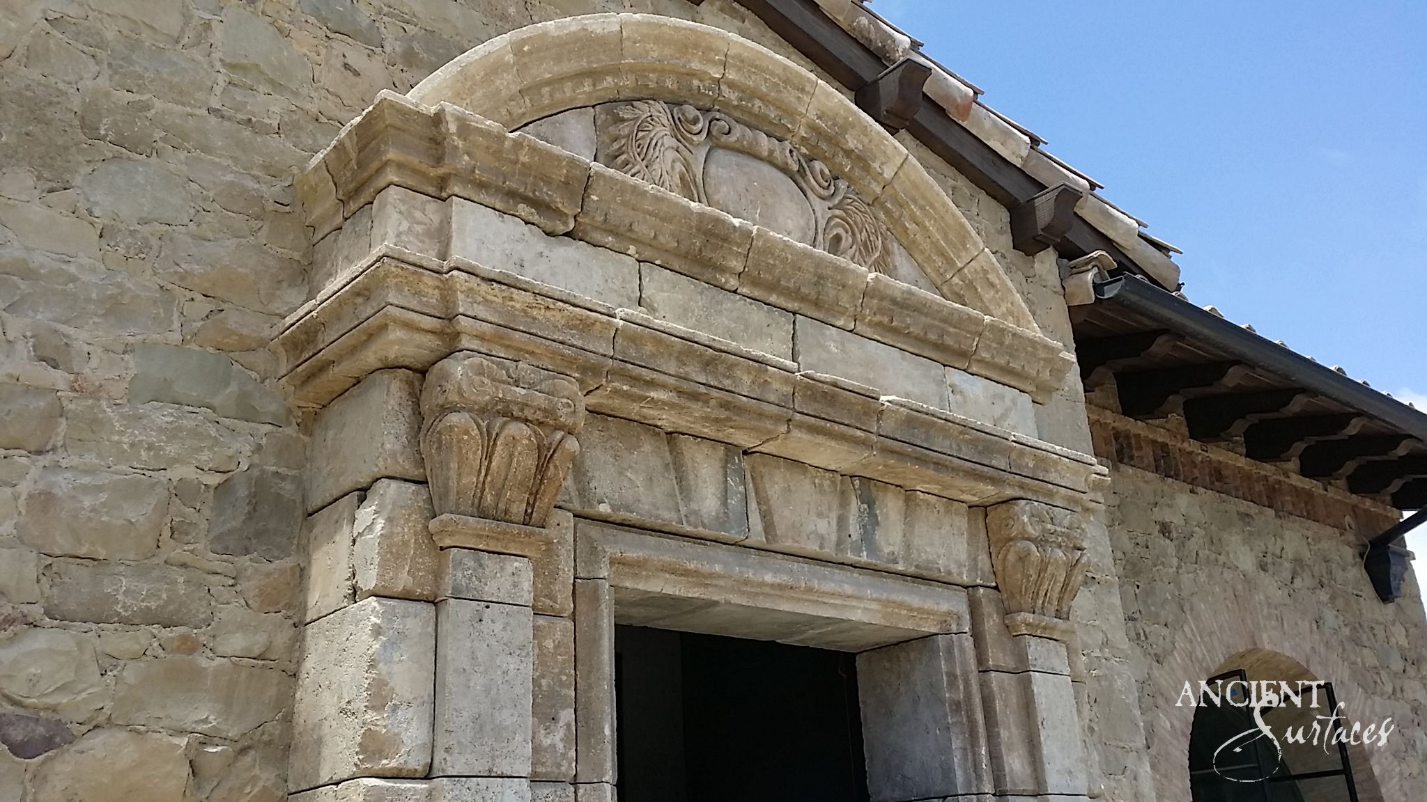 Grand reclaimed antique limestone arch framing an elegant entrance